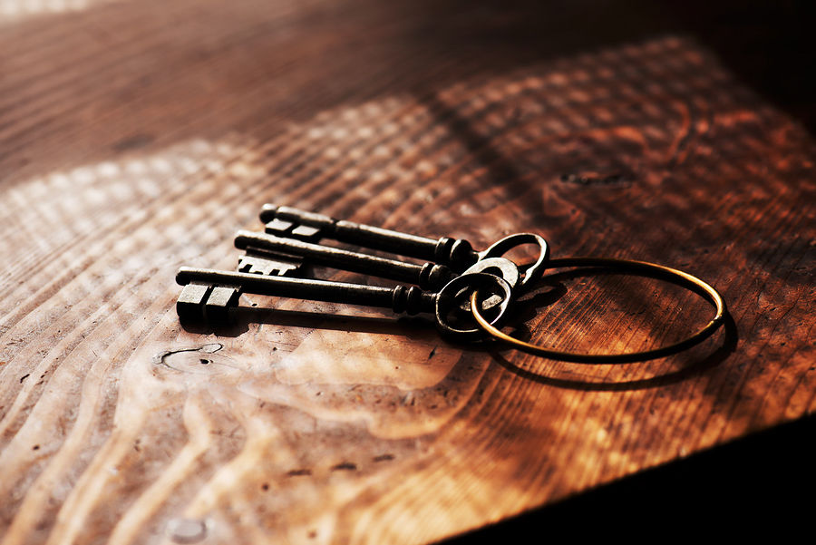 Vintage keys on an grungy old desk with window light shadow. Shallow depth of focus.